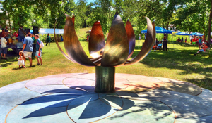 Outdoor garden installation of a large bronze flower